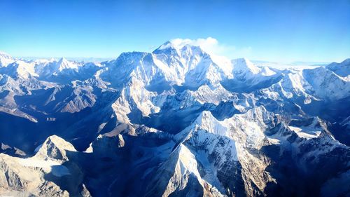 Scenic view of snowcapped mountains against blue sky