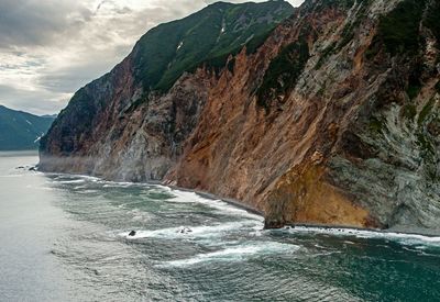 Scenic view of sea and mountains against sky