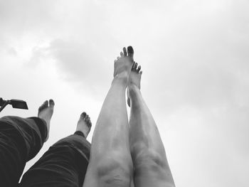 Low section of people with feet up against sky