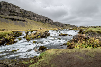 Scenic view of waterfall against sky