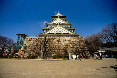 Low angle view of osaka castle against blue sky