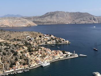 Aerial view of city by sea against sky