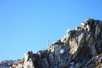 Low angle view of rock formation against clear blue sky