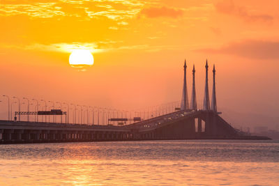 Bridge over river against sky during sunset