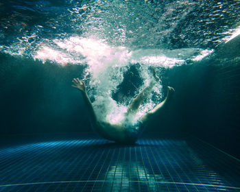 Man falling underwater in pool