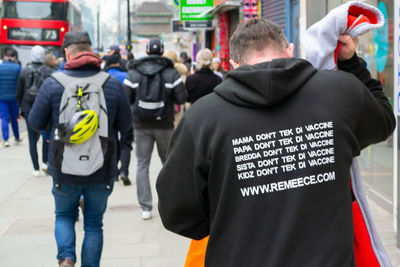 Rear view of people standing on street in city