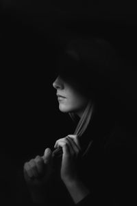 Portrait of young woman looking away over black background