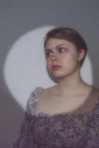 Portrait of a young woman against wall