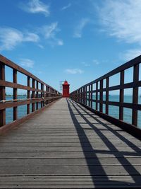 Footbridge over footpath against sky