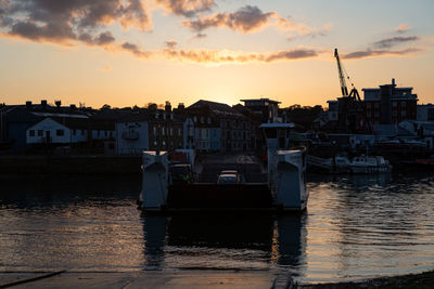 View of fishing boats moored at harbor during sunset