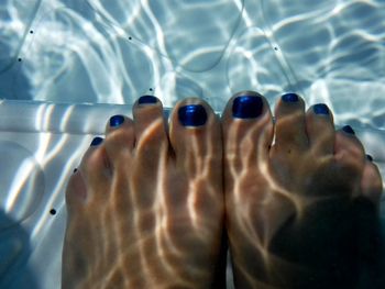 Low section of man relaxing in swimming pool