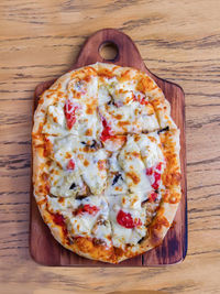 High angle view of pizza on cutting board