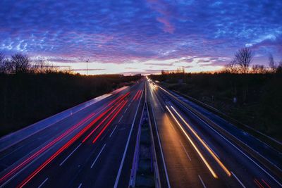 Light trails on highway against sky