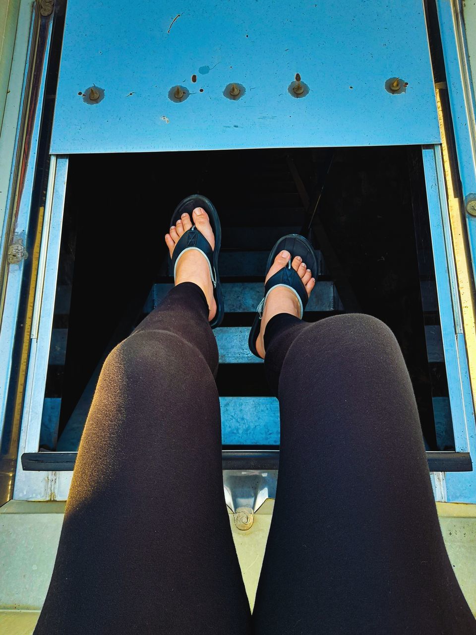 LOW SECTION OF WOMAN STANDING ON SWIMMING POOL