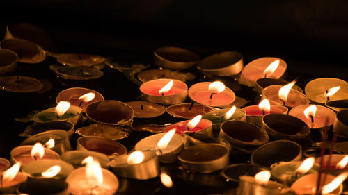 Close-up of lit candles on black background