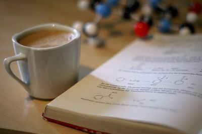 Close-up of coffee by book on table