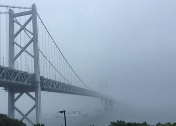 Low angle view of suspension bridge against sky