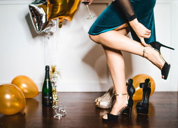 Low section of woman sitting on floor at home