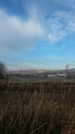 Scenic view of field against cloudy sky