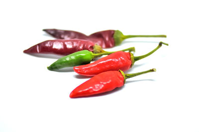 Close-up of red chili peppers over white background