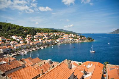 High angle view of townscape by sea against sky