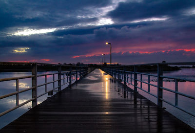 Pier over sea against sky during sunset