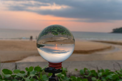 Close-up of water on beach against sky during sunset