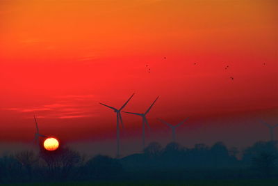 Low angle view of sunset with windmills in the background