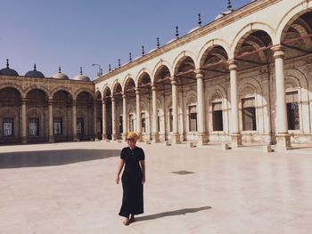 Woman standing by historic building