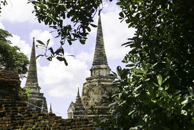 Low angle view of trees and building against sky