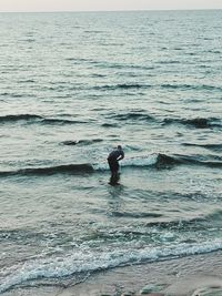 Man surfing in sea against sky