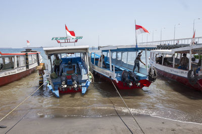 Boats moored in sea against sky