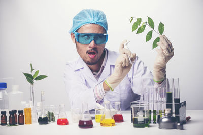 Man spraying chemical plant against white background