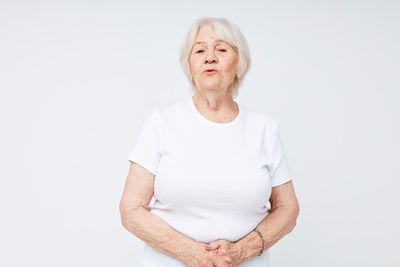 Portrait of young woman standing against white background