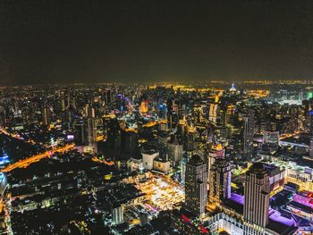 High angle view of illuminated cityscape against sky at night
