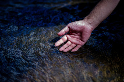 Close-up of hand touching rock