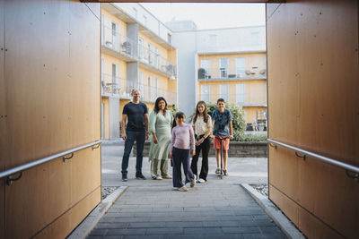 Portrait of family standing in courtyard of residential neighborhood