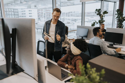 Young businessman discussing with businesswoman in office