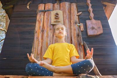 Portrait of young woman sitting on pier