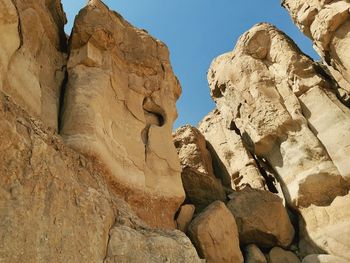 Low angle view of rock formations against sky