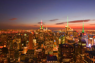 Illuminated cityscape against sky at night