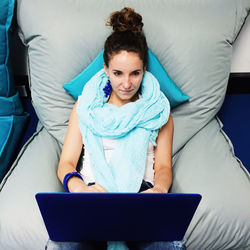 Portrait of young woman sitting on wall