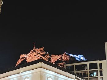 Low angle view of illuminated building against sky at night