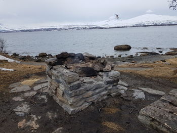 Rocks in sea against sky during winter