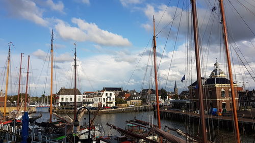 Sailboats in harbor against sky in city