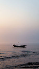 Silhouette ship in sea against sky during sunset