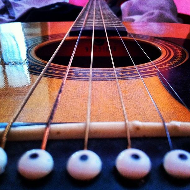 music, indoors, musical instrument, arts culture and entertainment, musical instrument string, musical equipment, guitar, selective focus, close-up, pattern, metal, illuminated, acoustic guitar, high angle view, string instrument, in a row, piano key, piano, no people, escalator