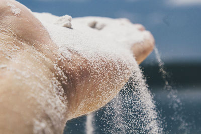 Close-up of human hand in snow