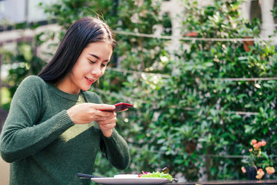 Young woman using mobile phone outdoors