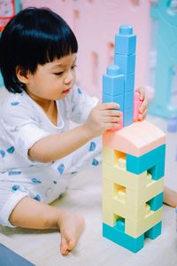 Cute girl playing with plastic toys